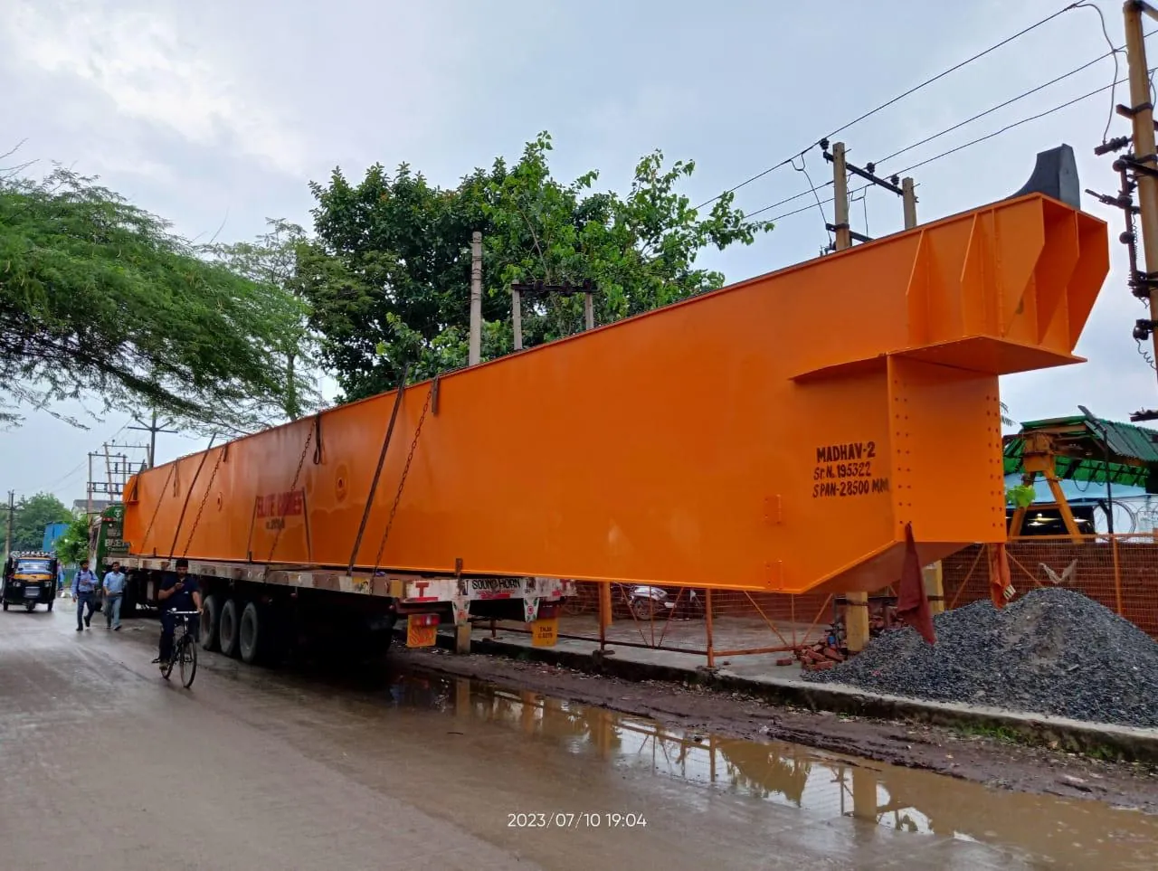 Orange overhead crane girder loaded on a trailer