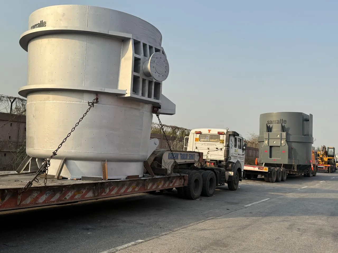 Large steel industrial vessels moving on low-bed trailers