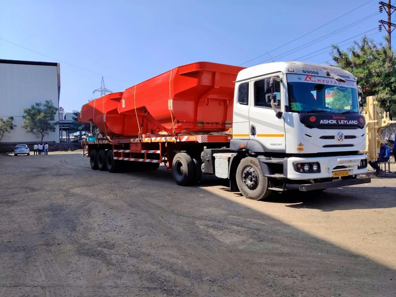 Truck carrying orange heavy equipment on a semi-trailer